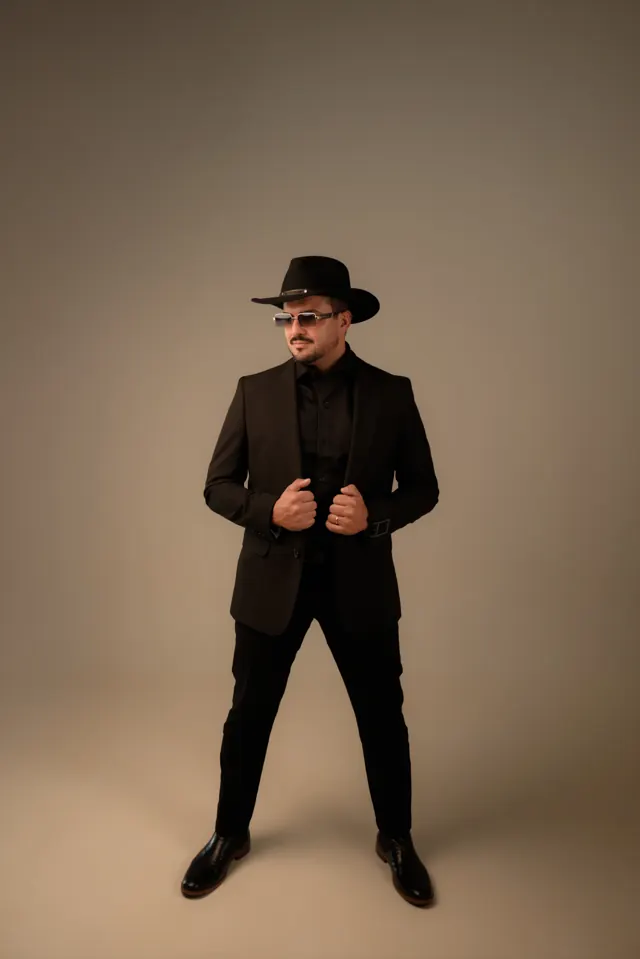 Fernando Marques de terno preto, chapéu e óculos escuros